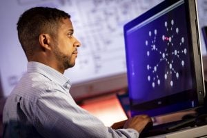 Side view of man working on his monitor.